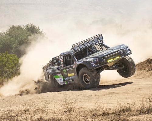 Offroad Racing Car Driving on a Dirt Road in a Cloud of Dust