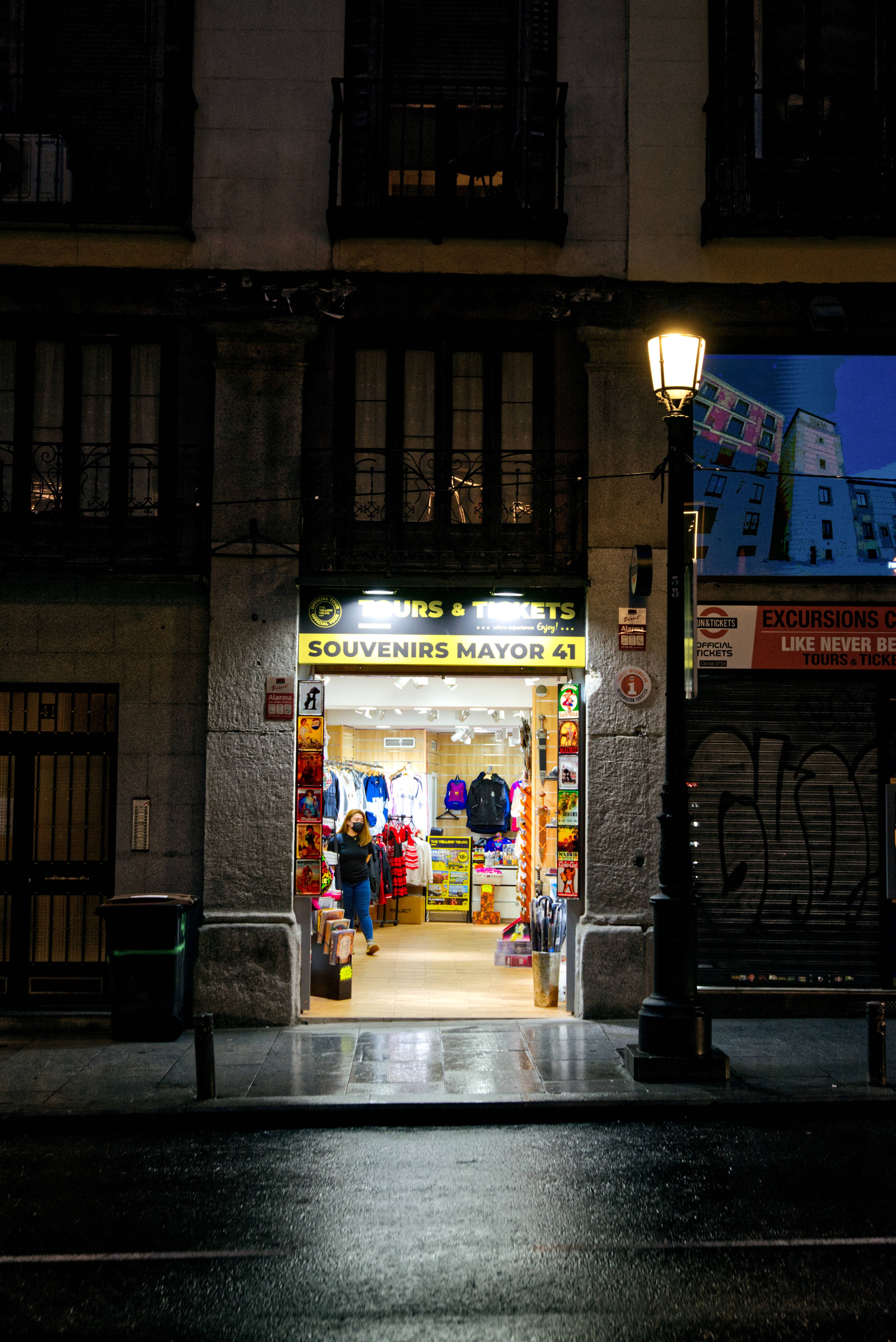 A cozy souvenir shop illuminated at night on a quiet street, creating a warm glow.
