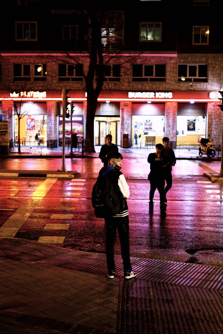 Photo Of People Crossing A Road During The Night