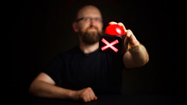A Person Holding a Red Buzzer