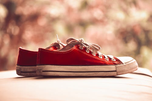 пара красных низких кроссовок в цвете Bokeh Photography