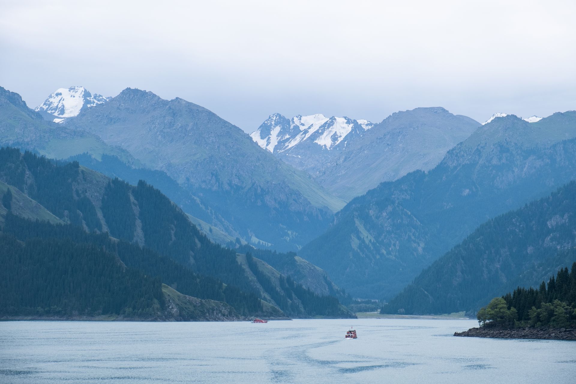 Majestic view of snowy Tianshan Mountains and Lake, Xinjiang, China. Perfect for nature and travel themes.