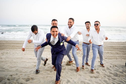 A Group of Men Catching the Running Groom in Blue Suit