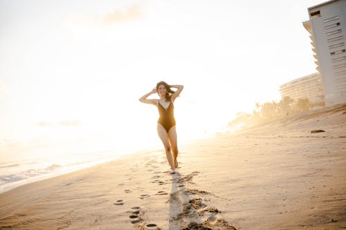 Woman in Black Swimwear Walking on the Beach