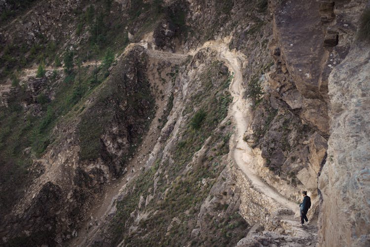 A Person Walking On The Cliff On A Rock Formation