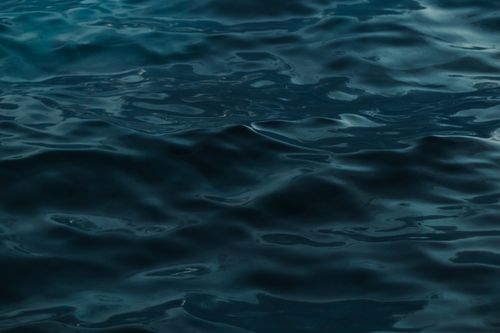 Free Close-up view of calm ocean water with gentle waves and dark hues. Perfect for backgrounds. Stock Photo