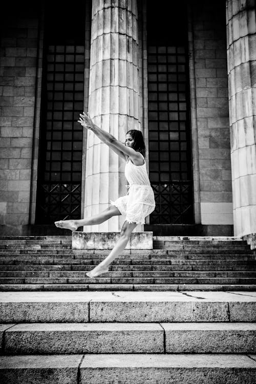 Grayscale Photo Of Woman Dancing On Stairs