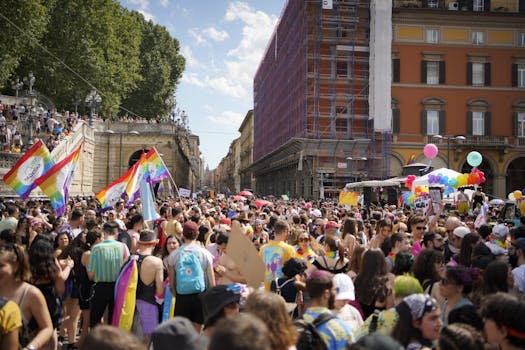A lively and colorful pride parade fills the streets of Bologna, Italy, with crowds celebrating diversity and inclusion.