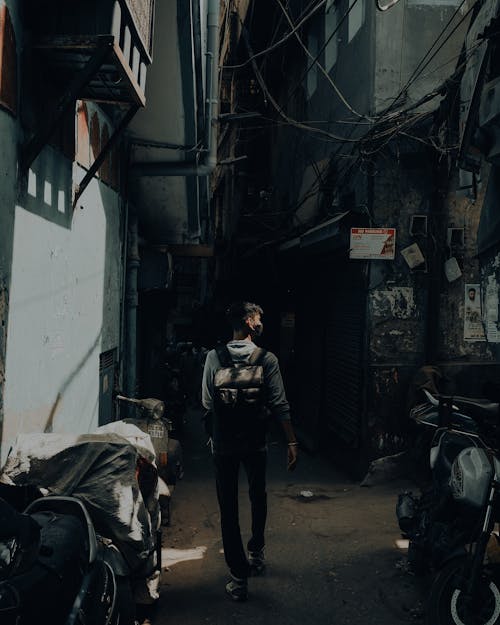 A Back View of a Man Walking on the Street