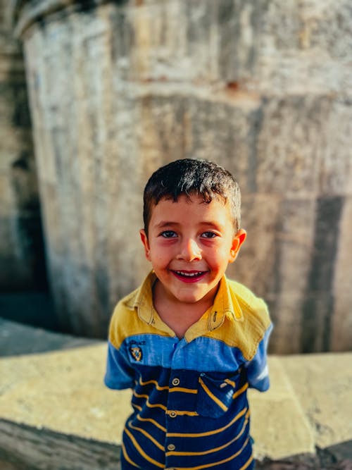 Foto profissional grátis de amarelo e azul, camisa polo, criança