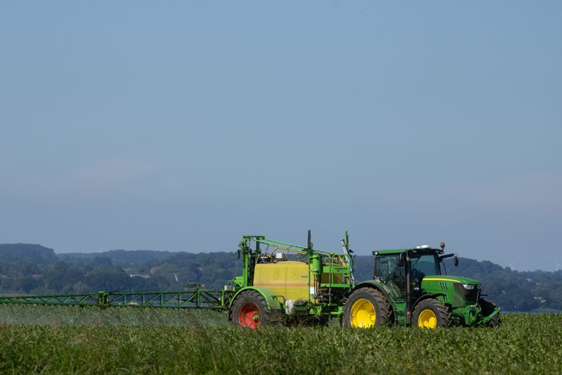 Tracteur appliquant un traitement sur un champ agricole