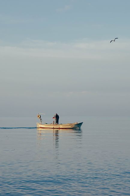 A serene scene of a lone sailor on a boat in Trabzon, Türkiye.