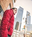 一名身穿红色夹克的男子站在纽约市的街景前