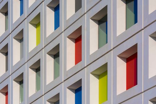 Free Vibrant modern facade with colored glass windows in geometric design. Stock Photo