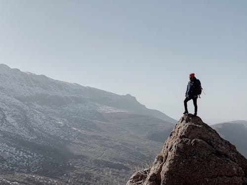 Photo of a Man Standing on a Rock