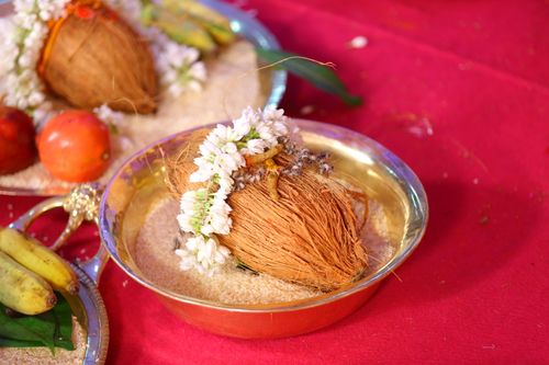 Free A coconut adorned with flowers in a decorative brass plate, used in Indian rituals. Stock Photo