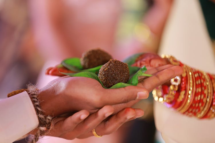 Women Holding Traditional Food In Their Hands