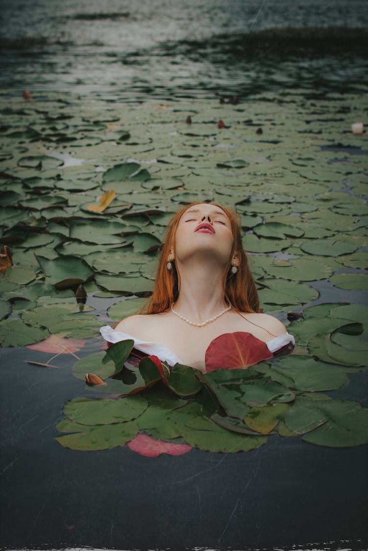 Woman In Water With Lily Plants