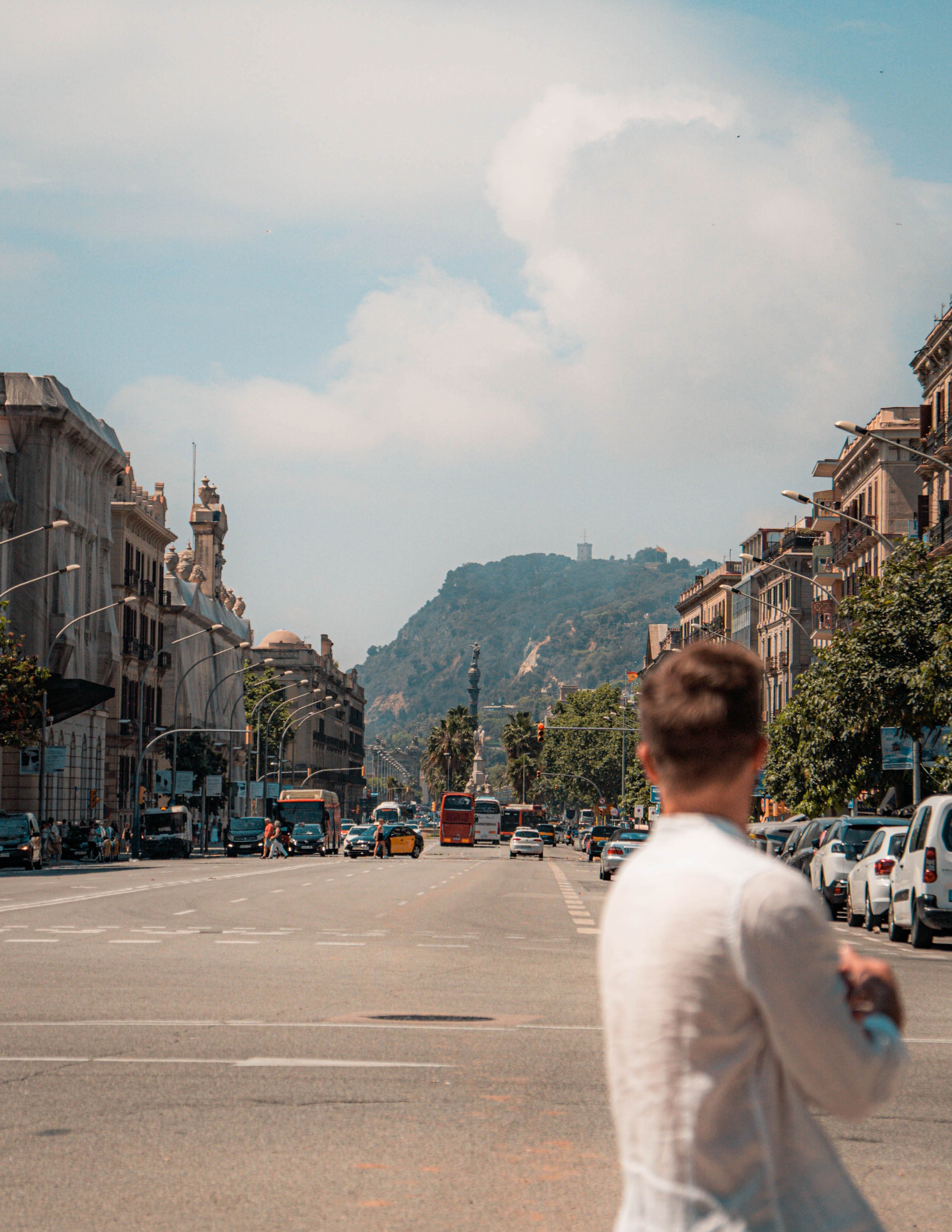 Street view in Barcelona with a blurred figure in the foreground, highlighting city life and architecture.