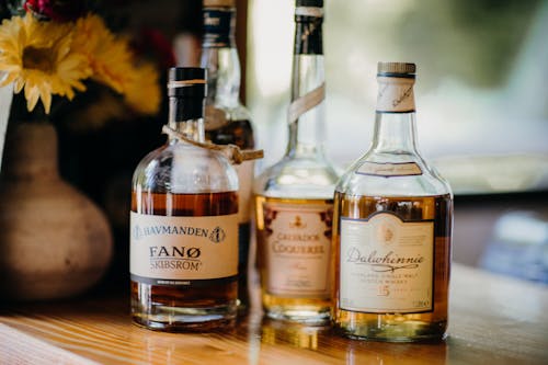 Photograph of a Bottle of Whisky Beside a Bottle of Rum