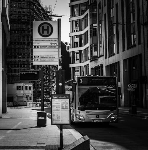 Grayscale Photo of a Bus near a Building