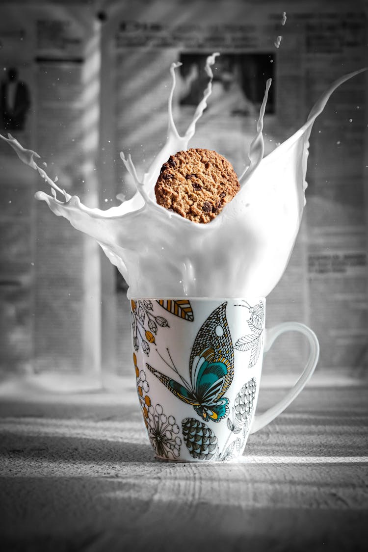 A Cookie Falling Into A Mug Of Milk