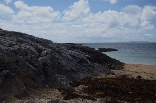 Free Stunning view of a rocky coastline and beach in Ireland under a bright blue sky. Stock Photo