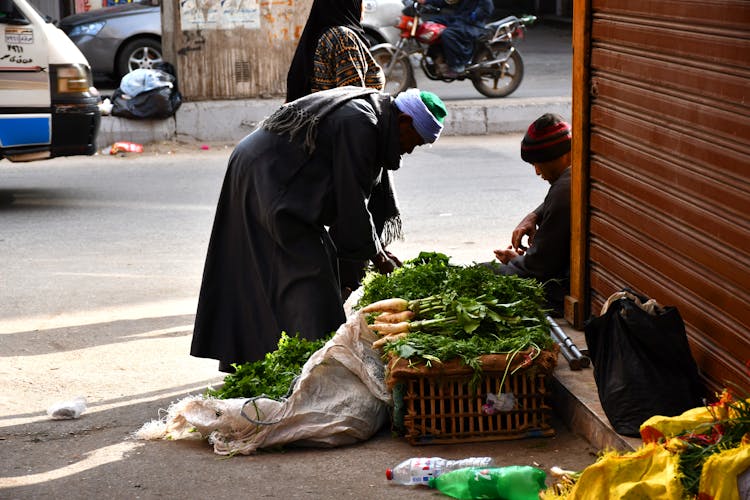 A Man Buying Vegetables On A Street