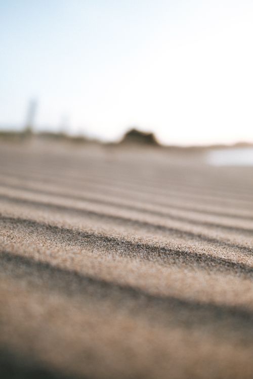 Free Close-up of rippled sand dunes creating texture in a serene, natural setting. Stock Photo