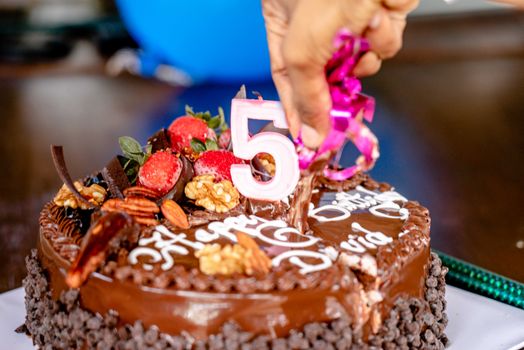 Close-up of a decorated chocolate cake for a 5th birthday celebration.