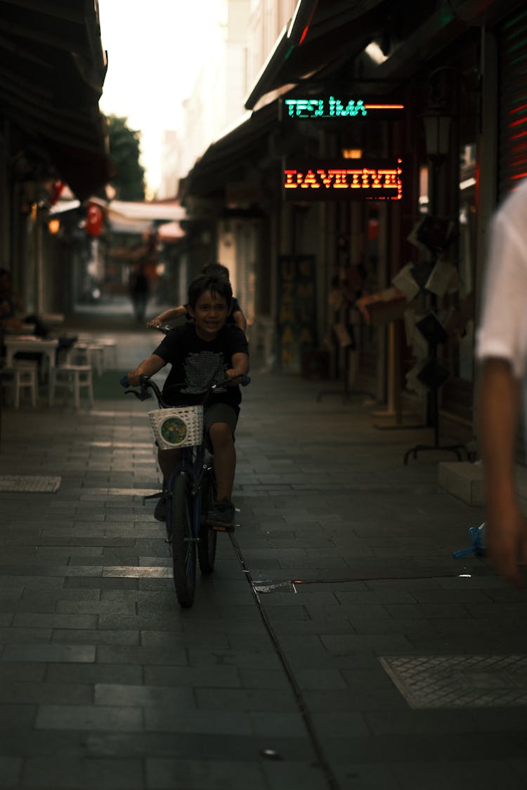 Kids Riding Bikes On A Narrow Alley