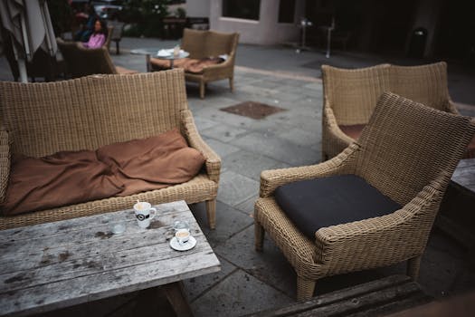 Charming outdoor cafe in Oslo with rattan seating and coffee cups on wooden tables, exuding a relaxed atmosphere.