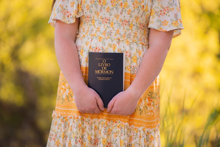 A Kid Holding A Mormon Book