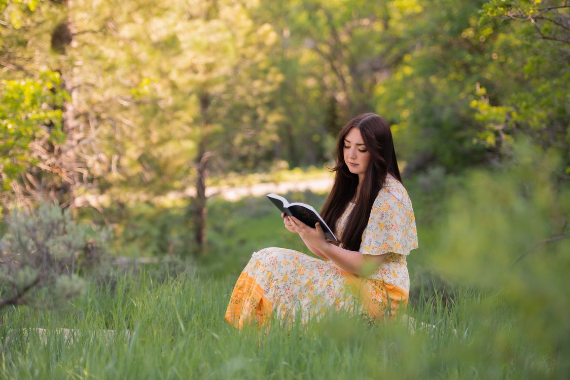 Woman Reader Woman Reading a Book on Green Grass · Free Stock Photo