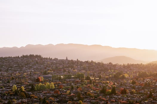 Stunning aerial shot of Vancouver suburbs with mountains silhouetted at sunset.