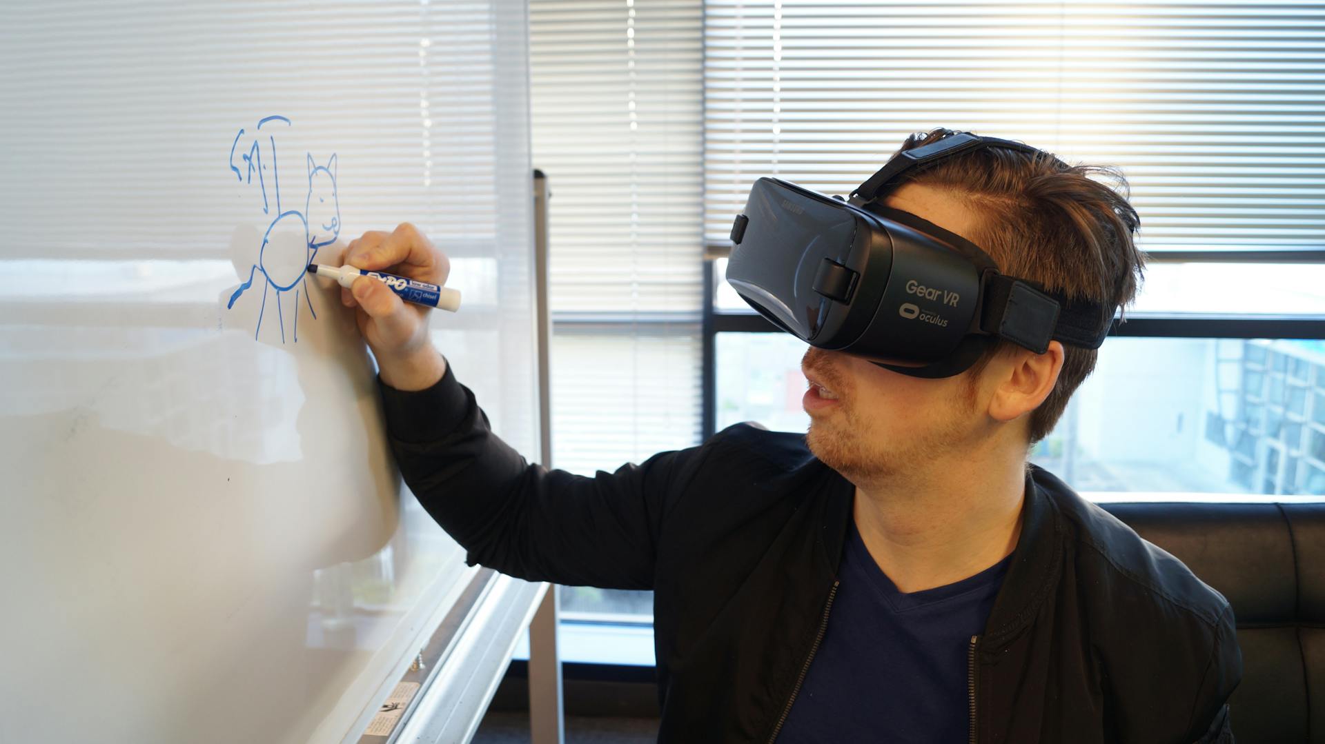 Person Wearing Black Vr Box Writing On White Board