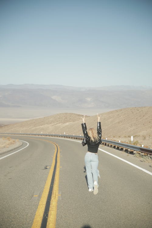 Back View of a Woman Walking on a Road