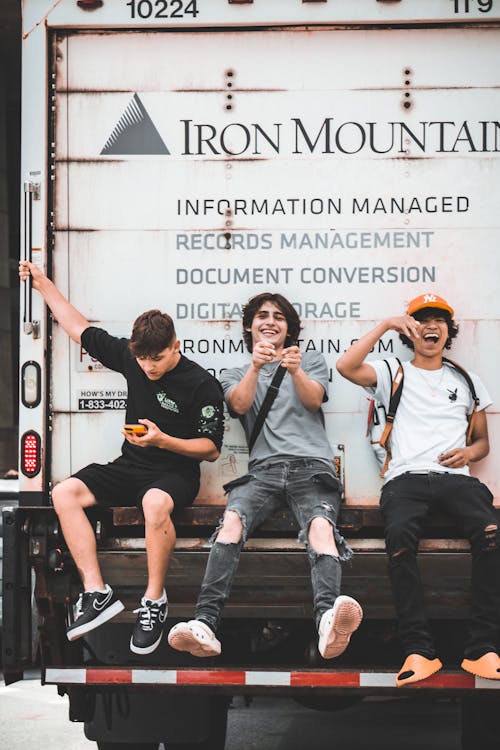 Photograph of Boys Sitting on the Back of a Truck