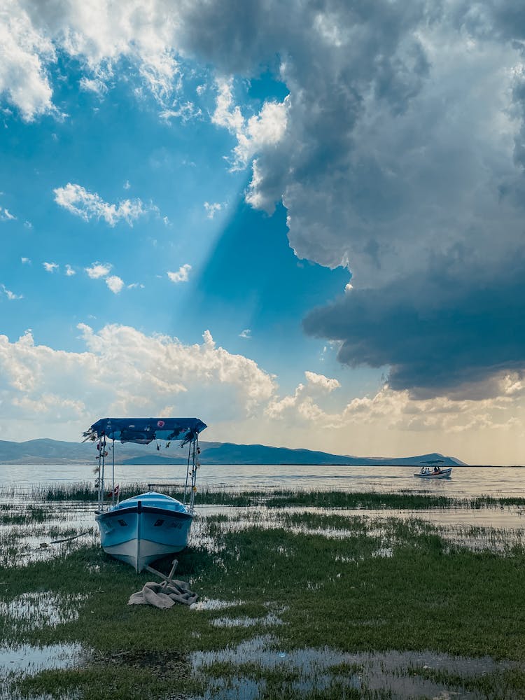 A White Boat Under A Cloudy Sky