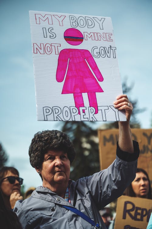 Free Woman Holding Banner during Protest Stock Photo
