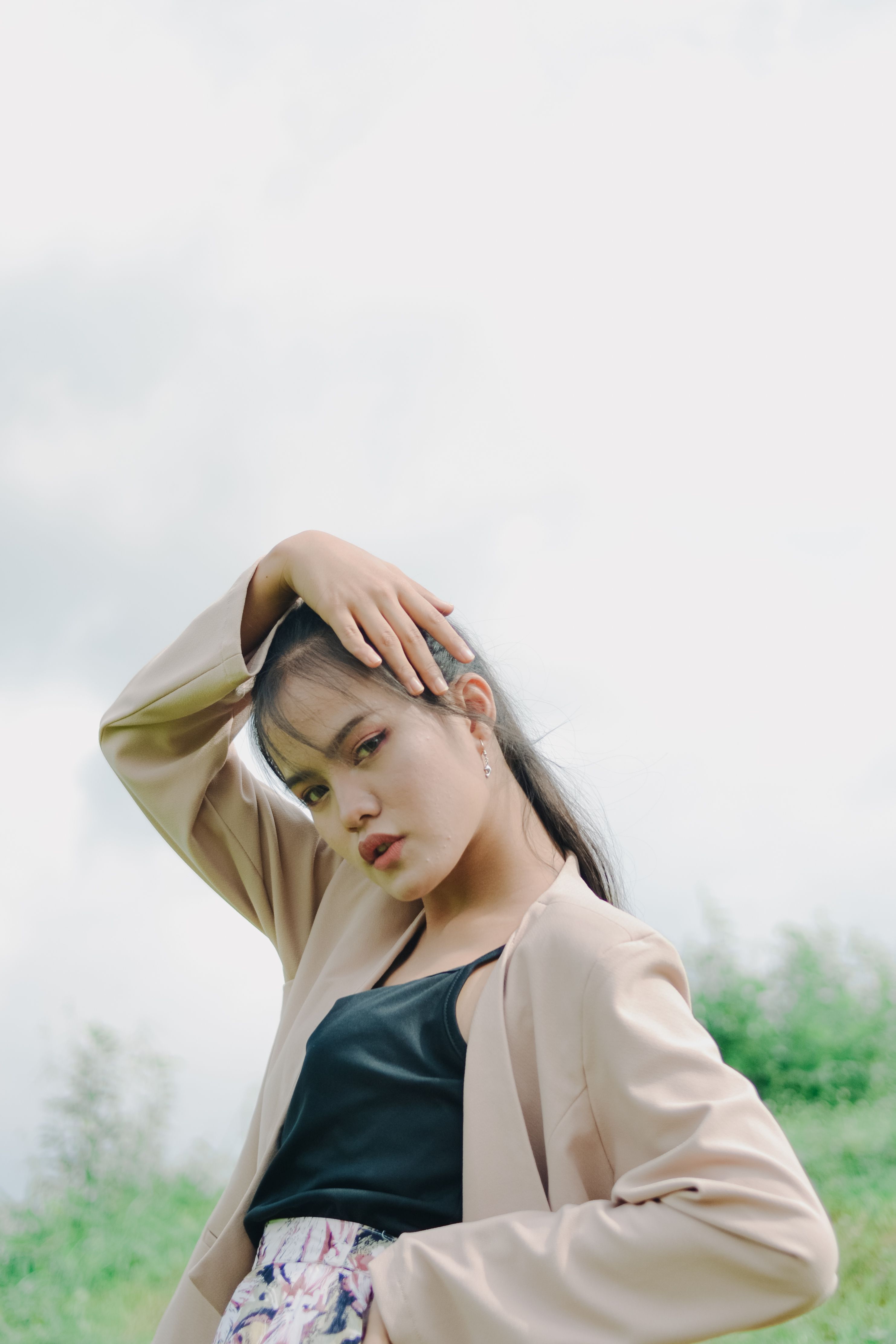 A Woman at the Beach Posing with Her Hand on Her Head · Free Stock Photo
