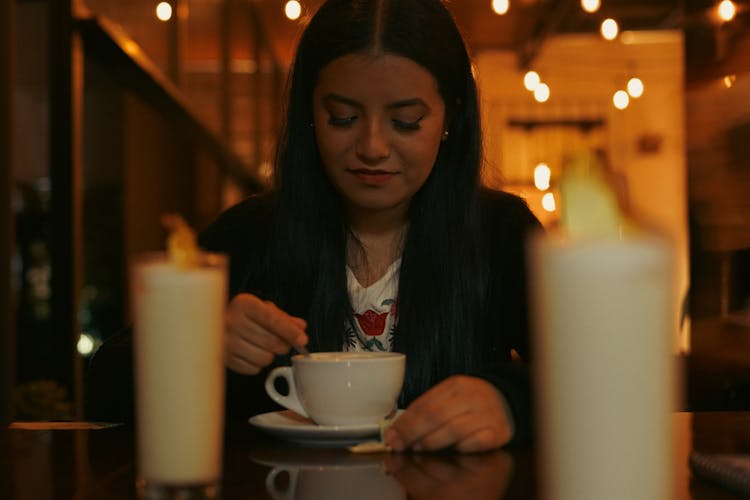 A Woman Stirring Her Drink