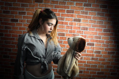 Woman Looking and Holding Brown Dog Plush Toy