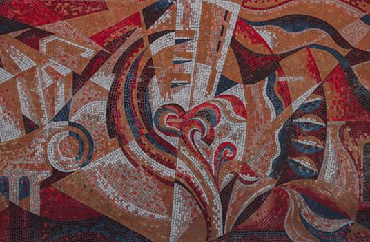 Dynamic abstract mosaic with red and earth tones, showcasing art and culture.