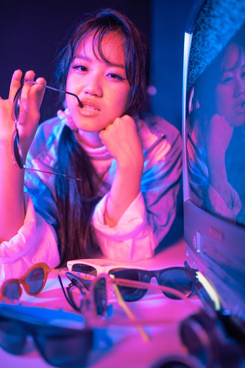 Portrait of a Woman Posing Beside a Television