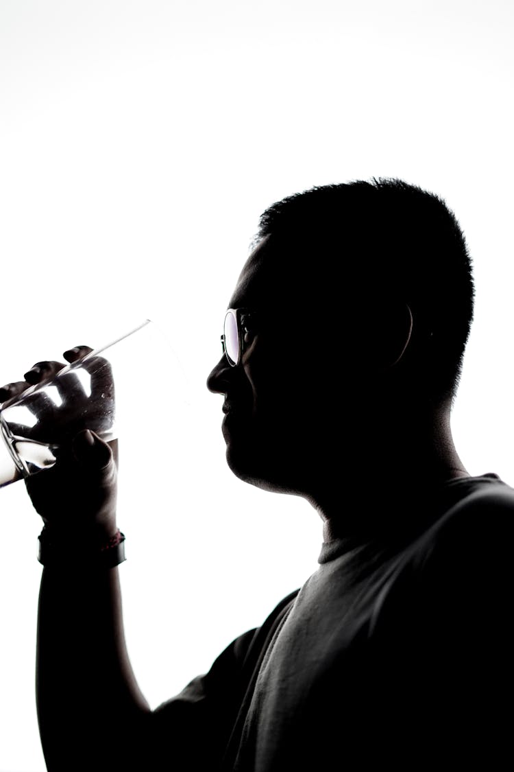 Silhouette Of Man Holding A Glass Of Water