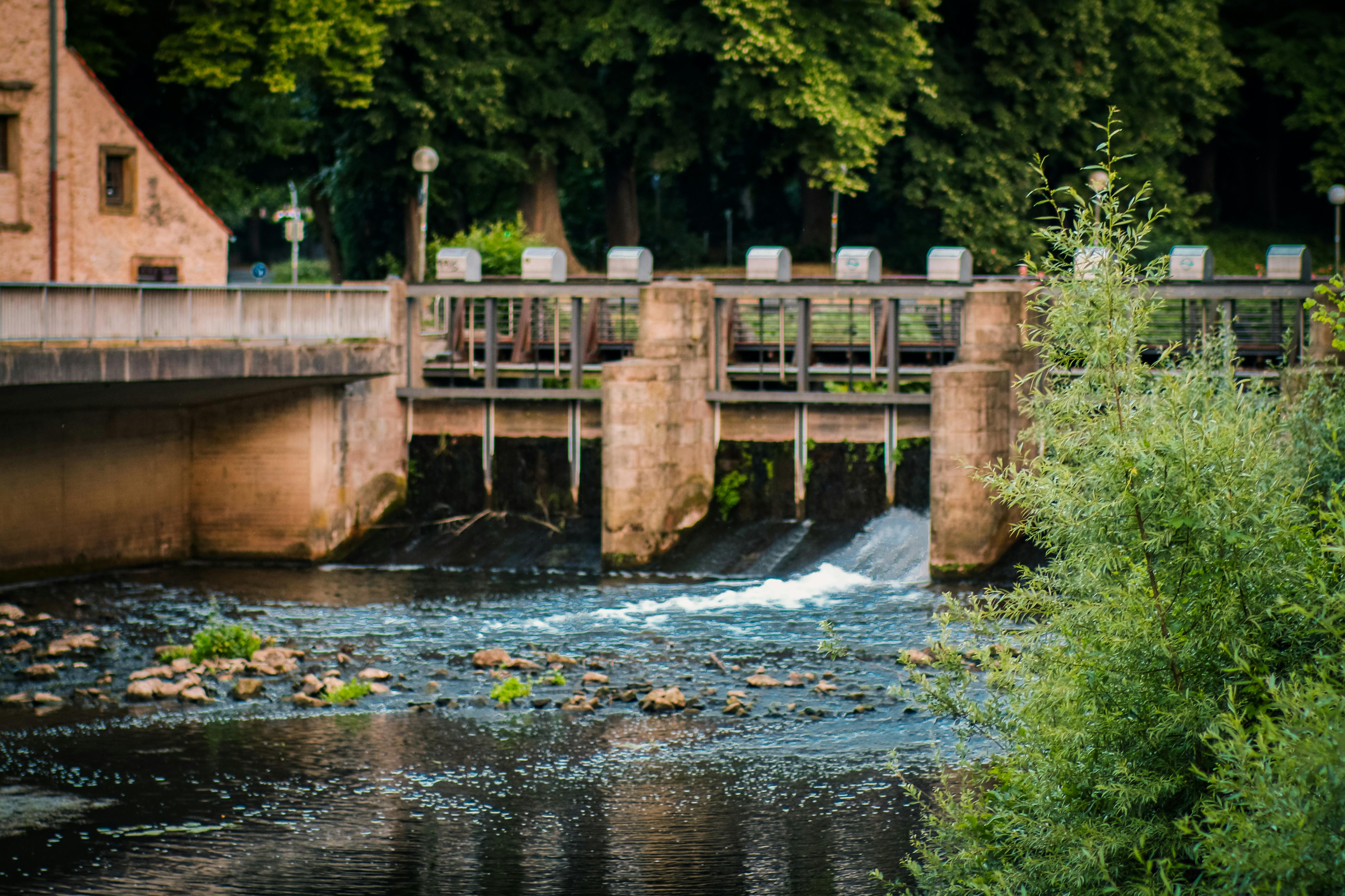 Serene view of a canal and bridge surrounded by lush greenery in Osnabrück, Germany.