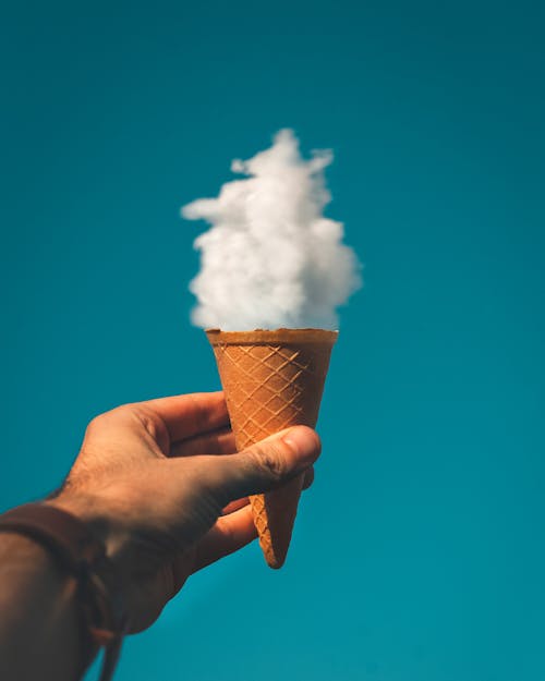 Free Man Holding Ice Cream Cone Under Cloud Stock Photo