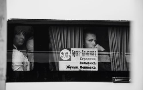 Free A black and white photo capturing thoughtful passengers gazing out a bus window. Stock Photo