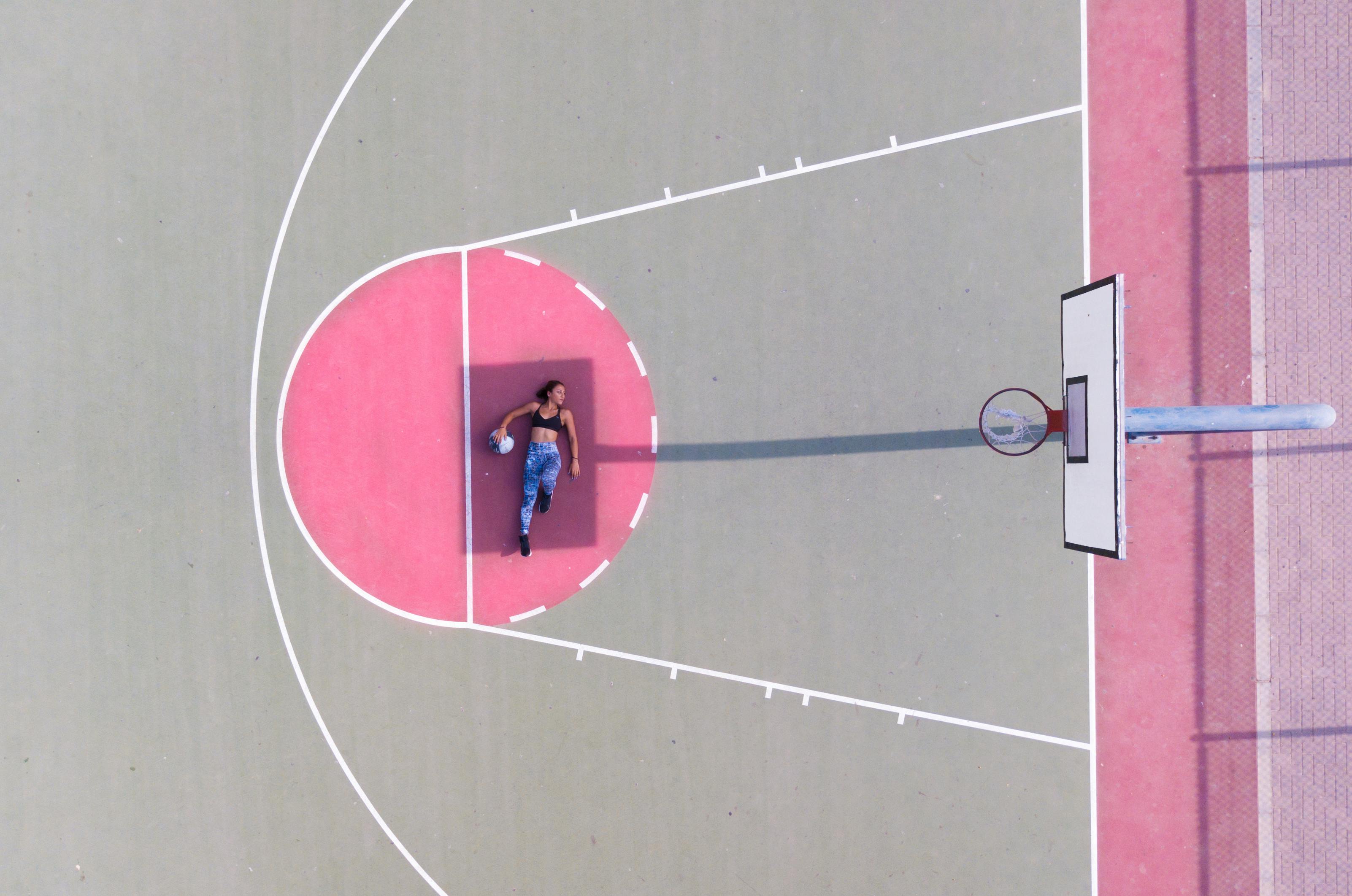 woman lying on basketball free throw line